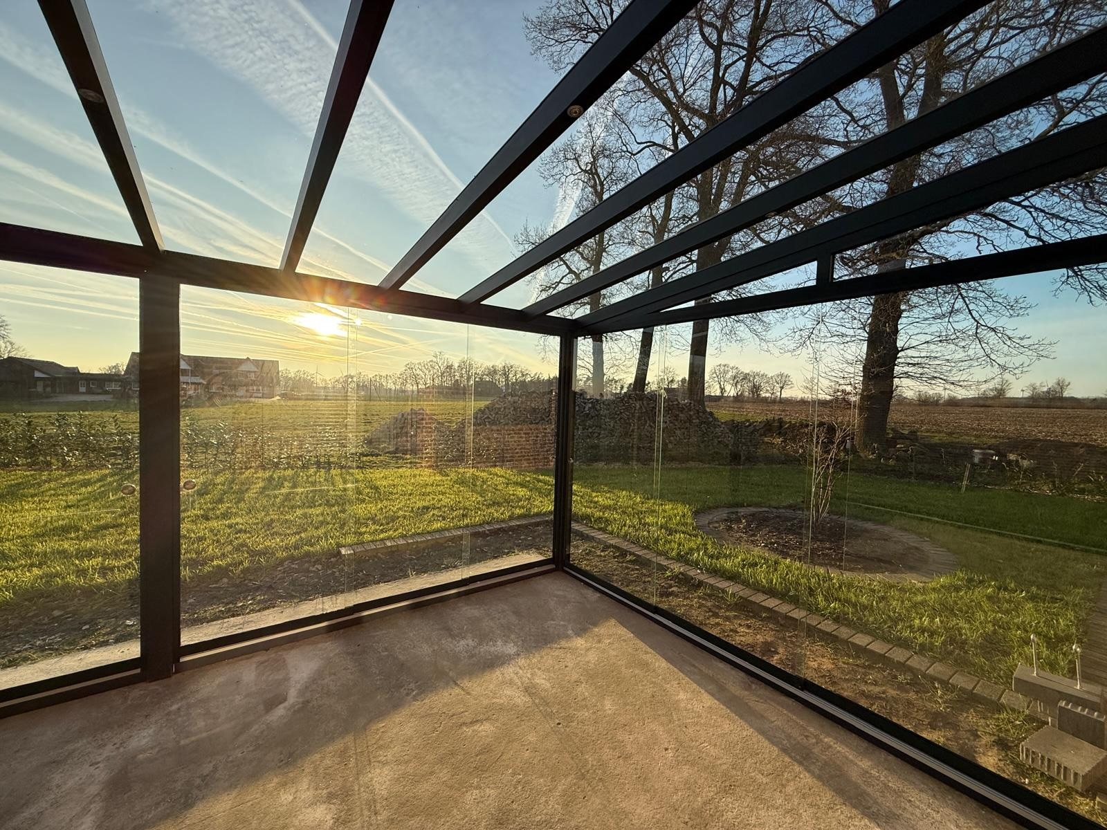 Innenansicht eines Kaltwintergartens mit Sonnenuntergang