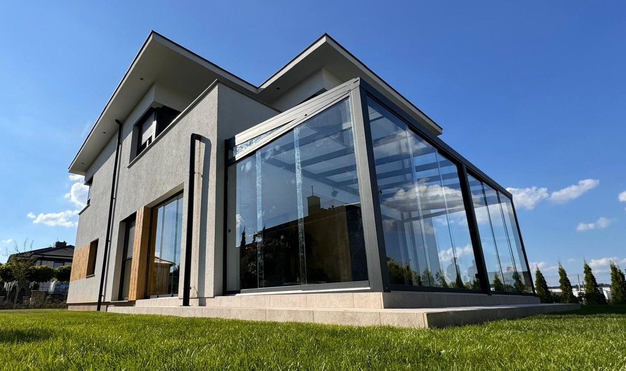 Hochwertiger Kaltwintergarten mit großer Glasfront an moderner Villa